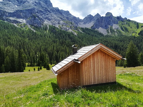 small isolated wooden cabin in the mountains of the Italian Dolomites