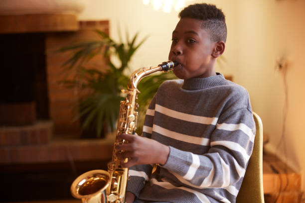 istock Young Musician: Son Hones Saxophone Skills in Home Practice Session 2029904612