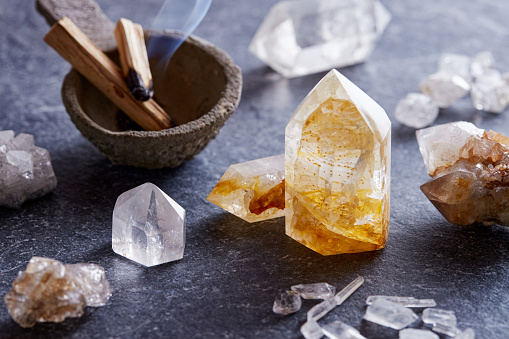 Gemstone crystals set on granite surface with burning palo santo wood, for spiritual and holistic therapy. Energy healing minerals set ready for spiritual practice and alternative medicine. Purification ritual with gem stones crystal and palo santo wood sticks.