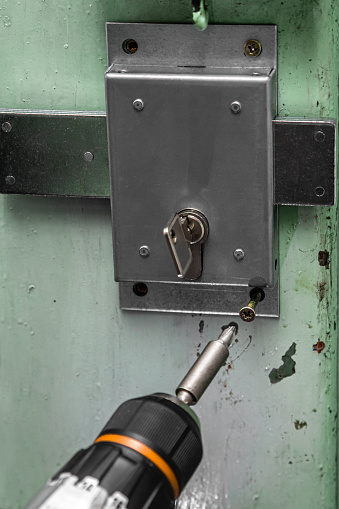 craftsman installs a door lock with deadbolt, drills a cylinder hole himself