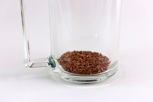 To prepare a decoction, flax seeds are poured into a glass. Medicinal properties of flax.