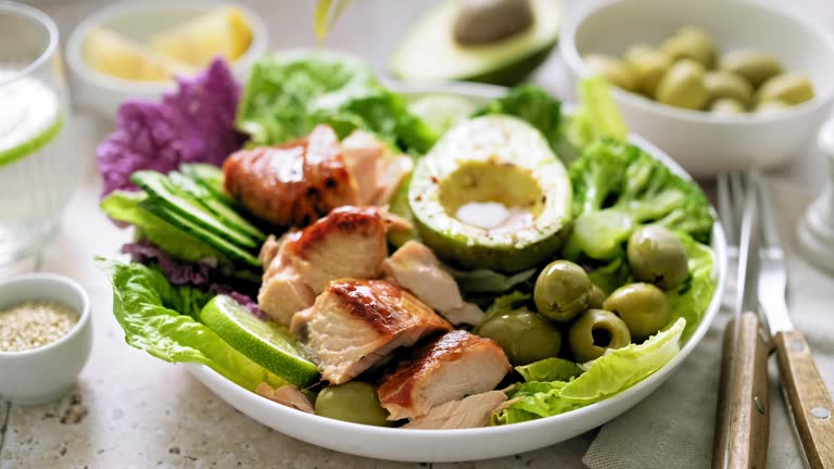 Salad bowl of salmon, avocado, broccoli, olives and fresh Romaine lettuce. Poke bowl salad, stock footage video 4K