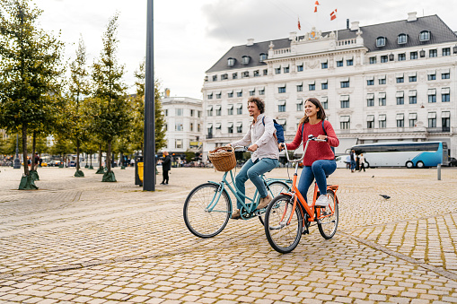 Young couple riding their bikes on the street in Copenhagen in Denmark.