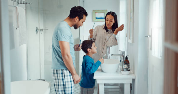 istock Parents, child and brushing teeth in family home bathroom while learning or teaching dental hygiene. A woman, man and kid with toothbrush and toothpaste for health, cleaning mouth and wellness 2029952969