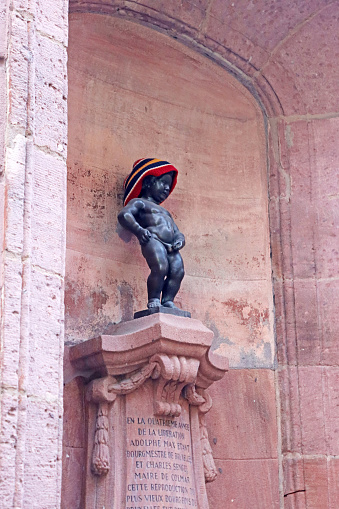 Colmar, France - December 21, 2023: Replicate statue of manneken pis from belgium in alsatian fountain