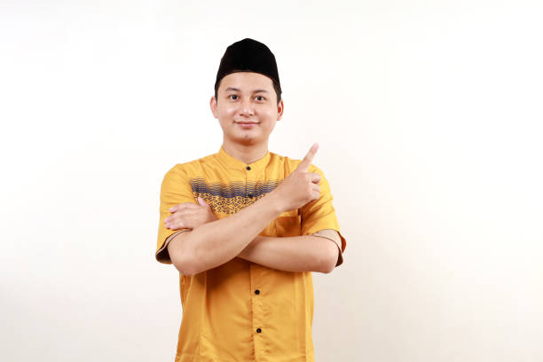 istock Asian muslim man pointing something on his side with his hand over white background 2029973538