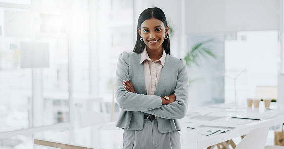 Business woman, portrait and smile with arms crossed in an office for confidence and career pride. Professional entrepreneur person from India at corporate company with positive attitude or happiness