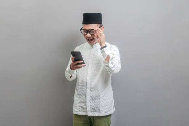 istock Asian Muslim man smiling reading a message on his smartphone 2029997165