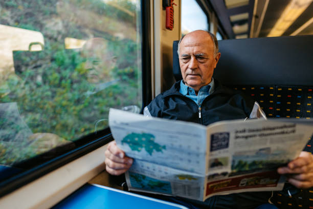 istock Senior Man Reading A Newspaper While Riding In A Train In Switzerland 2030000727