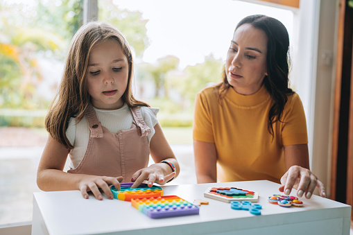 mother playing with autistic daughter