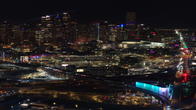 Denver downtown Colfax i25 highway traffic aerial drone snowy winter evening dark night city lights landscape skyscraper Colorado cinematic anamorphic pan up reveal forward motion