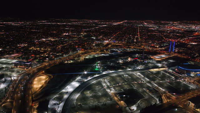 Downtown Denver i25 traffic snowy winter evening night city lights landscape aerial drone cinematic anamorphic highway Colorado Mile High DU Metro Eltiches Empower Field Ball Arena circle to the left