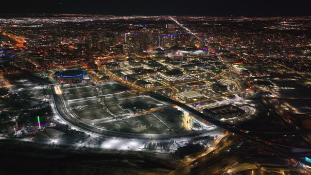 Downtown Denver i25 traffic snowy winter evening night city lights landscape aerial drone cinematic anamorphic highway Colorado Mile High DU Metro Eltiches Empower Field Ball Arena reveal pan forward
