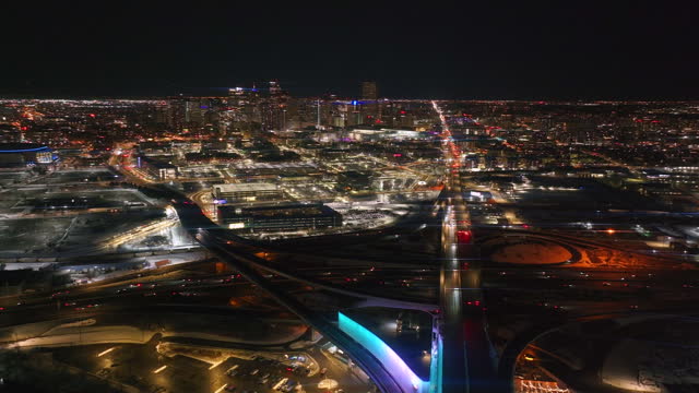 Denver downtown i25 highway traffic aerial drone cinematic anamorphic snowy winter evening dark night city lights landscape Colorado Mile High DU Metro state Ball arena forward pan reveal motion