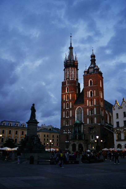 St Mary's Basilica through Cloth Hall archway in Rynek Główny medieval main square, Krakow, Poland. Krakow city in Poland was originally the capital of the country until 1956 but is now best known for its well-preserved medieval centre with its period architecture and spacious Rynek Glówny market square as well as the Jewish quarter and ghetto areas.