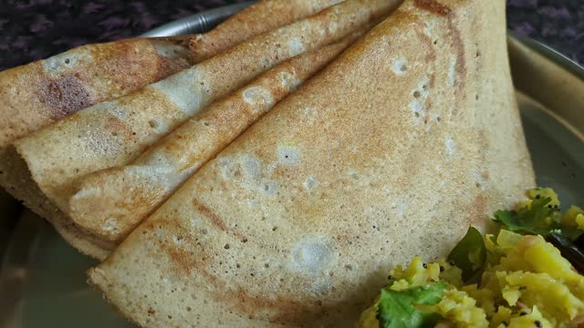 Panoramic video of homemade soft crispy dosa with mashed potatoes served on a silver plate