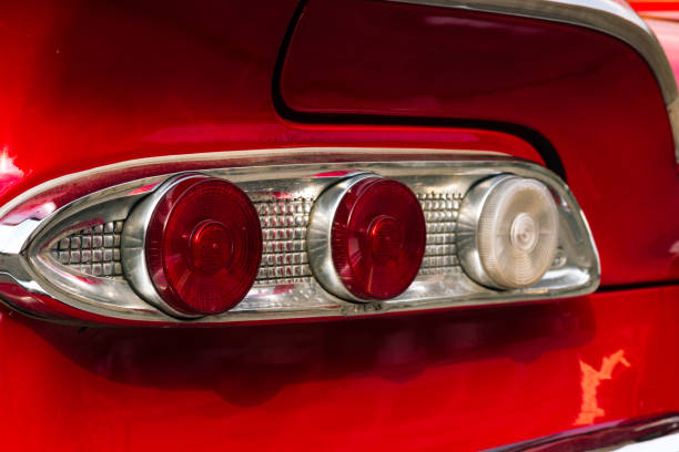 Simple red car stop light extreme close-up detail, abstract red background texture rear vehicle lighting, creative automotive backdrop for car dealerships, service repair shops design element, nobody