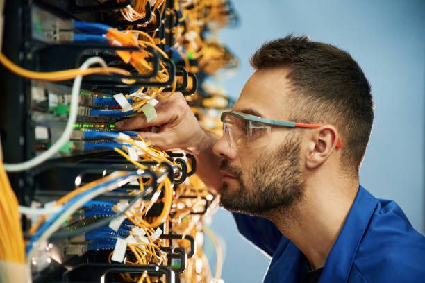 istock Looking extremely close at cables. Young man is working with internet equipment and wires in server room 2030106082