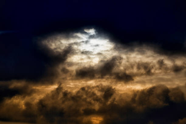 Evening sunlight breaks through dark clouds, gloomy light in the sky