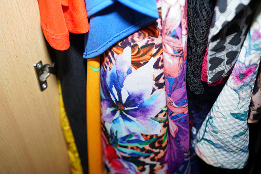Wardrobe overflowing and colorfully mixed with jackets and pants, sweaters and bags