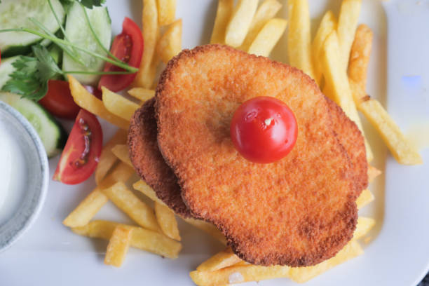 top view of Chicken schnitzel served with potato chips .