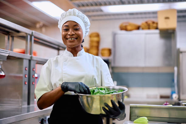 istock Happy black female cook working in a restaurant and looking at camera. 2030120420