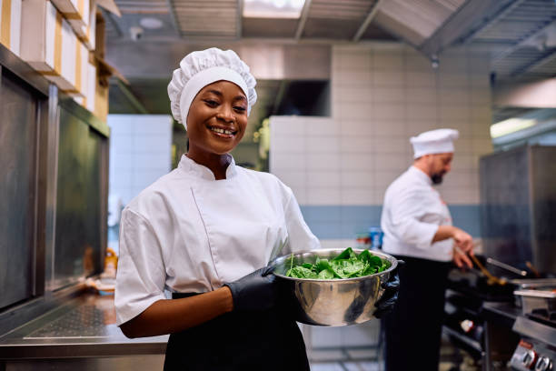 istock Happy black assistant chef working in the kitchen and looking at camera. 2030123279