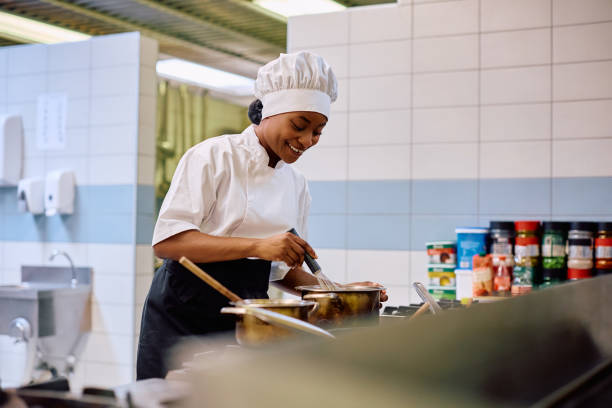istock Happy black female chef cooking in the kitchen in a restaurant. 2030124178