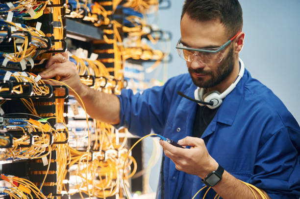 istock Checking signal by device. Young man is working with internet equipment and wires in server room 2030126956