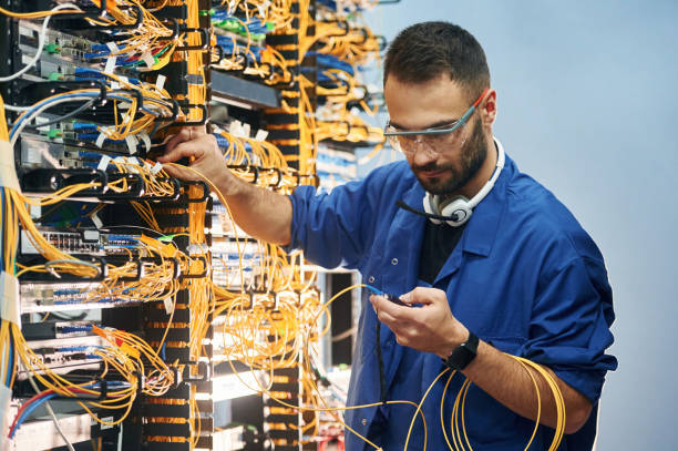 istock Checking signal by device. Young man is working with internet equipment and wires in server room 2030126964
