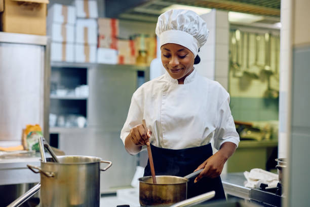 istock Young black female cook preparing a dish in a restaurant. 2030128560