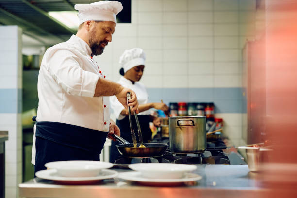 istock Professional cook preparing a dish in restaurant kitchen. 2030128588