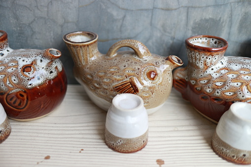 Brown clay teapot on white white background, studio shot.