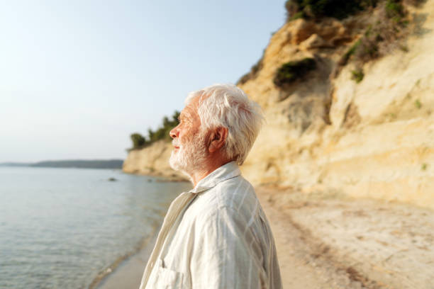 istock Senior man taking a walk down the beach 2030131326