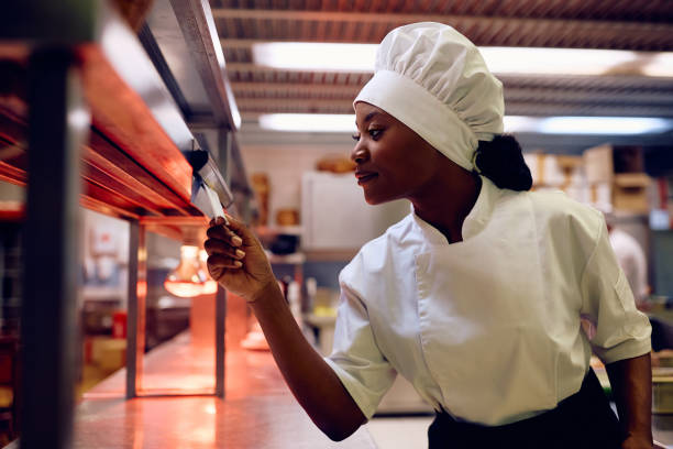 istock Black female cook checking the order while working in a restaurant kitchen. 2030131835