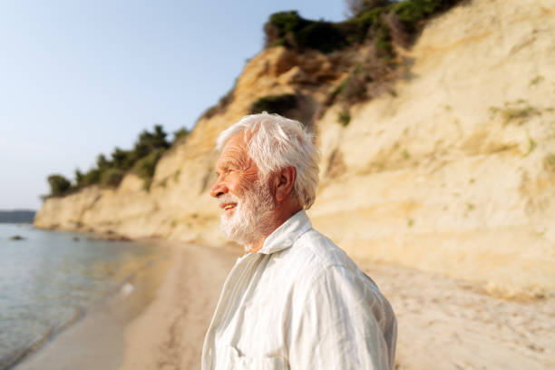 istock Senior man taking a walk down the beach 2030131860