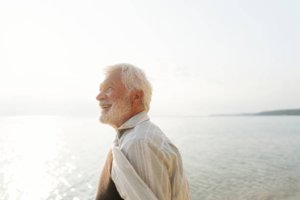 Photo of a senior man having a his daily walk routine done on the beach by the sea