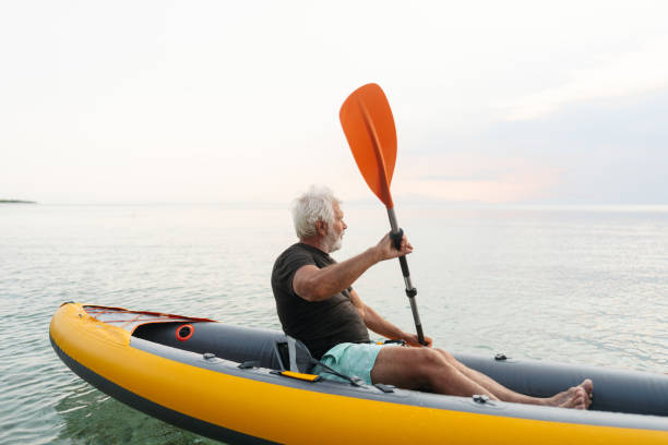 istock Senior man kayaking at sunset 2030140780