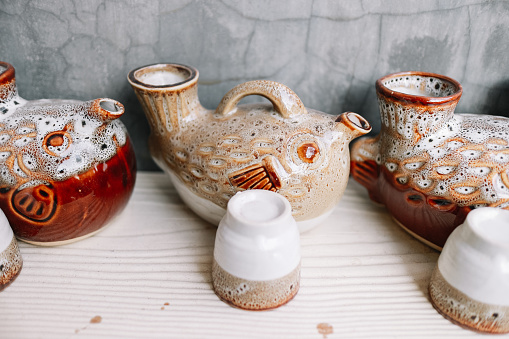 Colorful covered with glaze ceramic handmade mug. Isolated on a white background