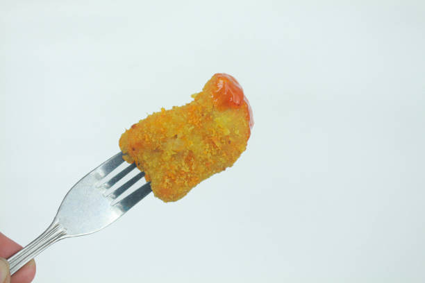 istock Chicken nuggets and chili sauce with a fork. Isolated in white background. 2030167884