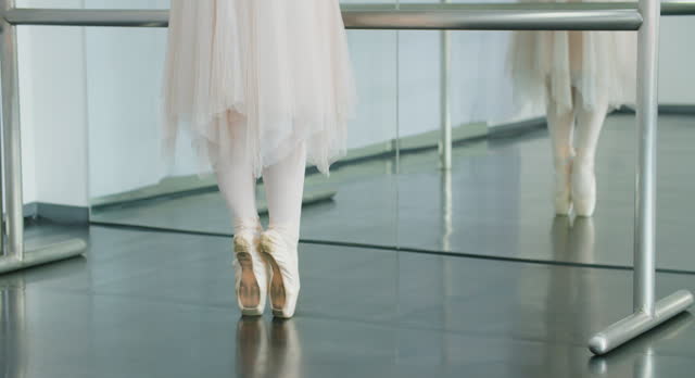Close-up Unrecognizable Ballerina's Legs Performing in Pointe Shoes at Studio.