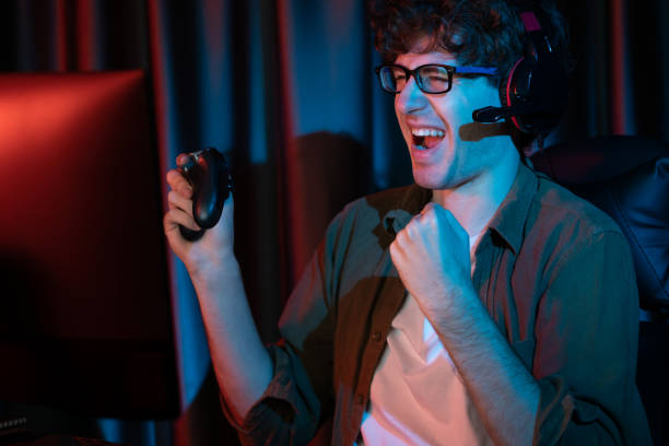 istock Smiling streamer winning with joystick, focusing Esport team on pc. Gusher. 2030174030