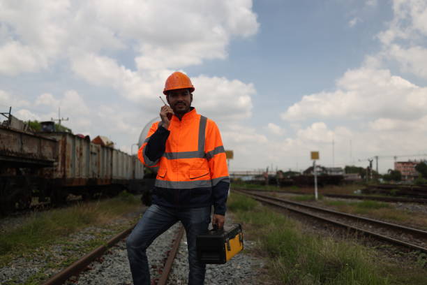 istock Portrait smart maintenance engineer with an orange reflection jacket standing on the railway track as background. Ready to work in transportation industrial concept. 2030178637