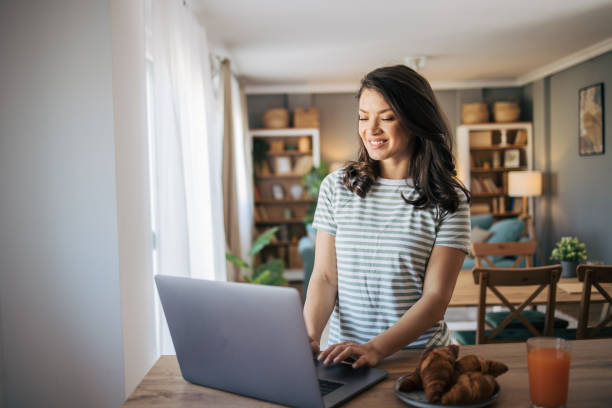 istock beautiful smiling woman using laptop at home. 2030186354