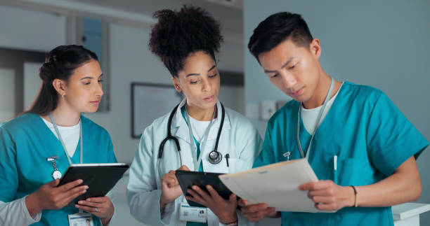 istock Teamwork, discussion and doctors on tablet and documents in hospital for research, report and advice. Healthcare, clinic and people talking on digital tech for medical service, results and meeting 2030197540