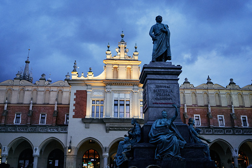a statue on the main square of Krakow in the evening