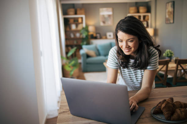 istock beautiful smiling woman using laptop at home. 2030220599