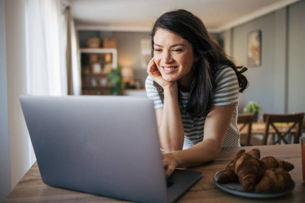 istock beautiful smiling woman using laptop at home. 2030220605