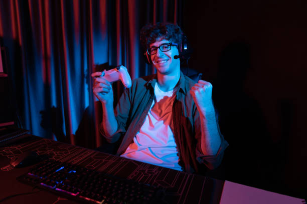 istock Smiling streamer with joystick, focusing Esport team on pc with harder. Gusher. 2030223868