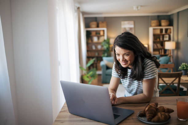 istock beautiful smiling woman using laptop at home. 2030231093